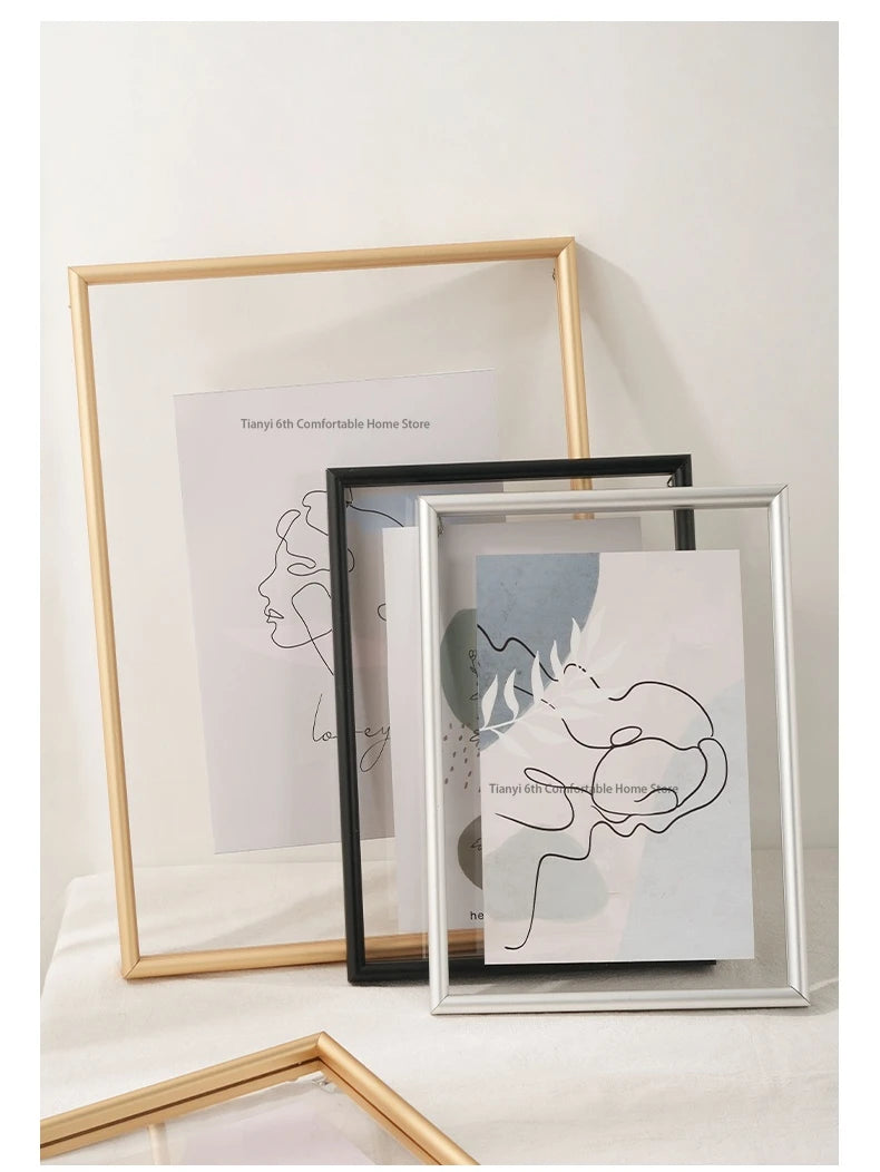 Three framed artworks with different frames on a light surface.