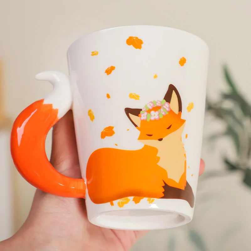 Mug with a fox design held by a hand against a neutral background