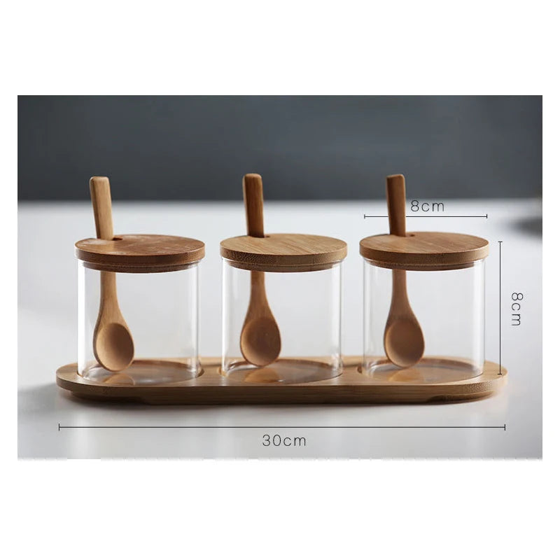 Three glass jars with wooden lids and spoons on a wooden tray, with measurements indicated.