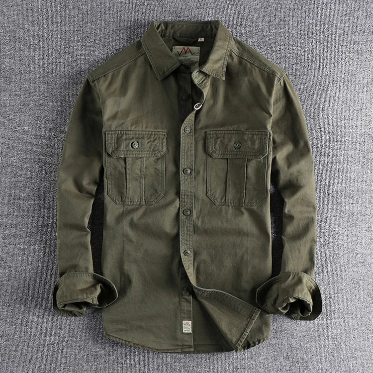 Green jacket with rolled-up sleeves on a gray textured background