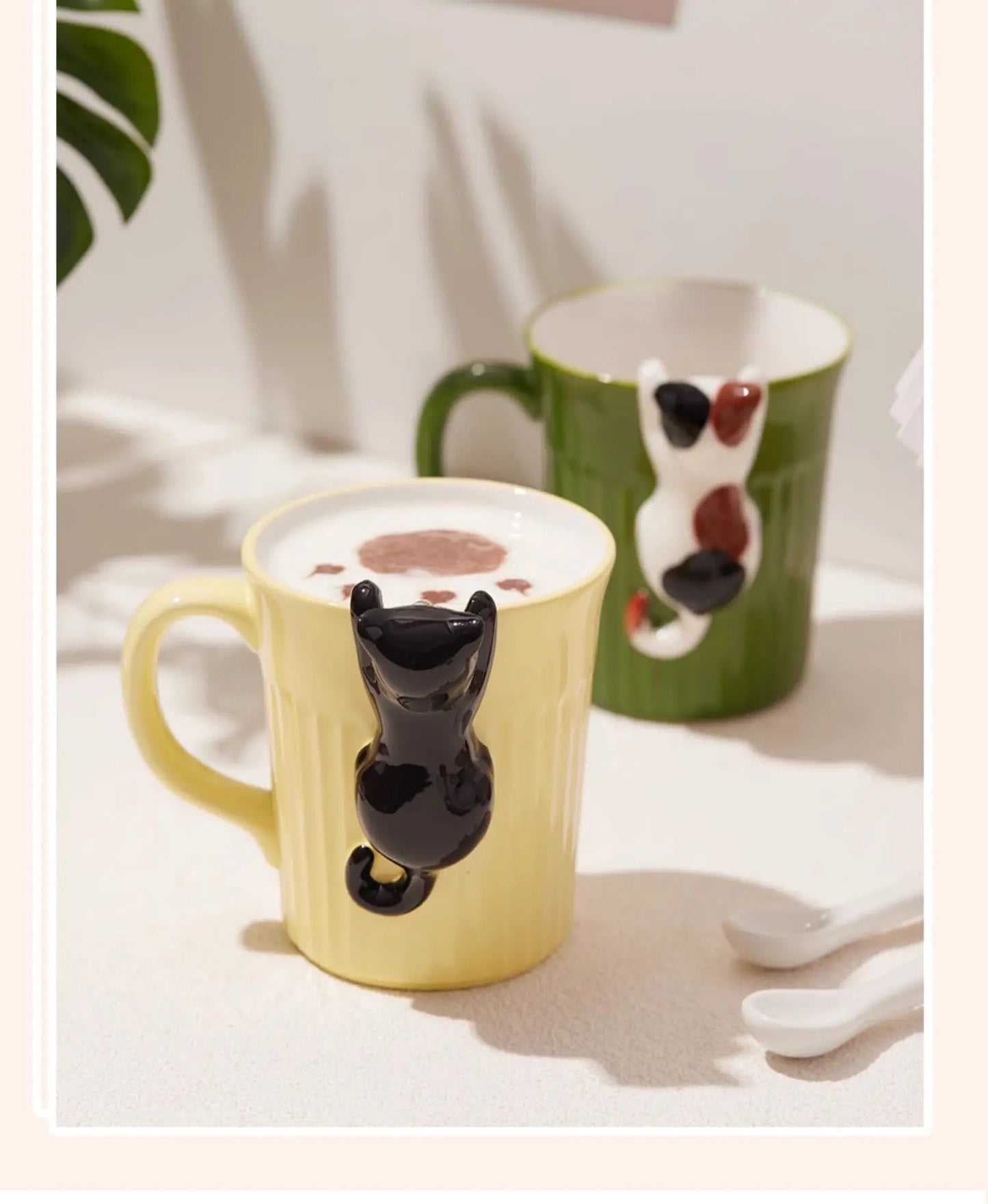 Green and yellow ceramic cat mugs with a 3D cat climbing over the rim.