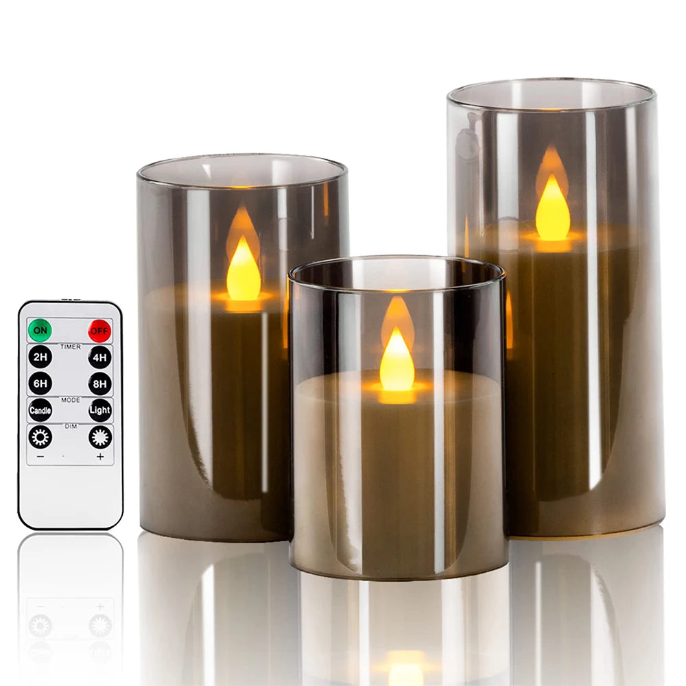 Set of three smoked glass candle holders with glowing candles and a remote control on a white background.