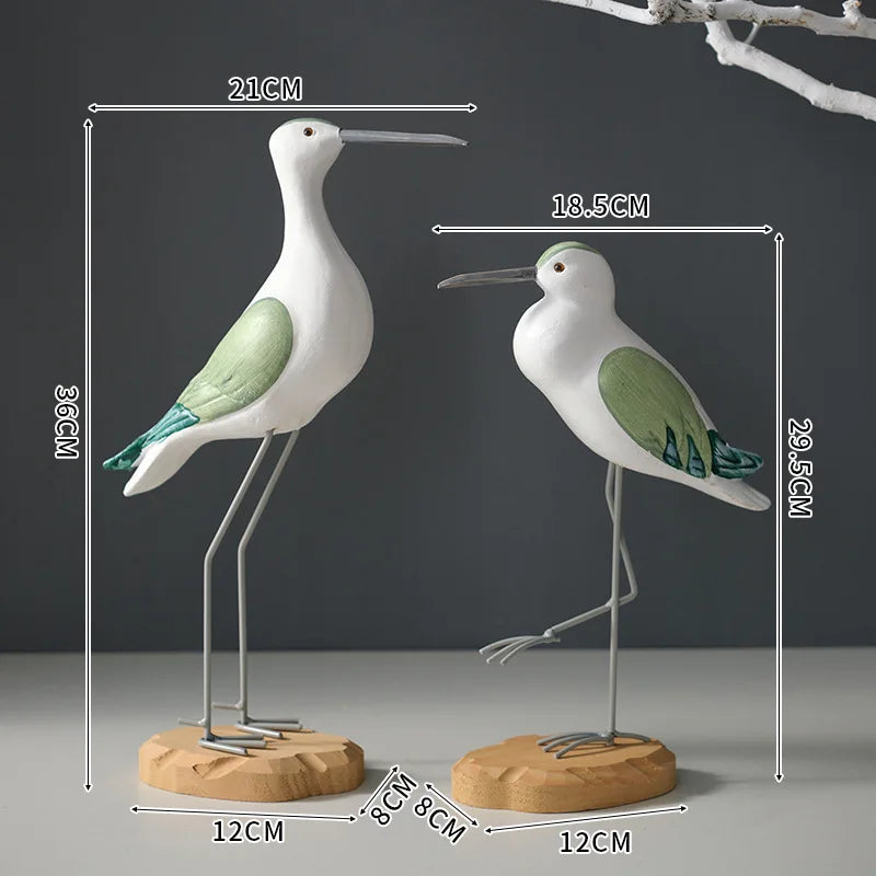 Two bird-shaped sculptures with measurements on a dark background
