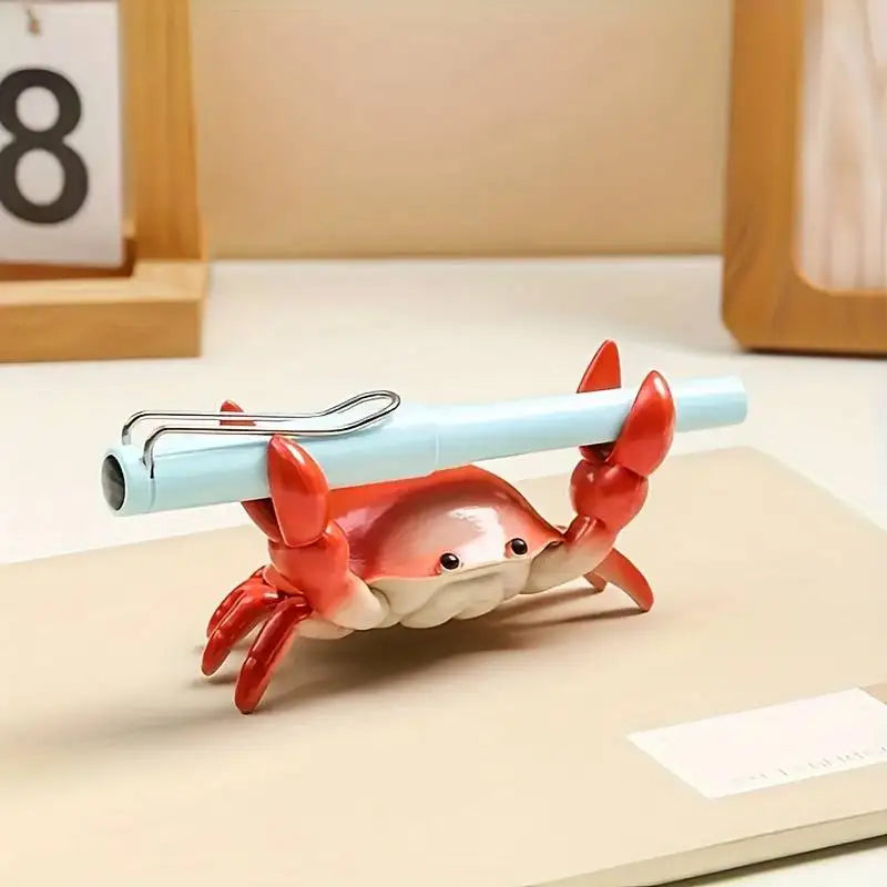 Pen holder shaped like a crab on a desk with a pen inside