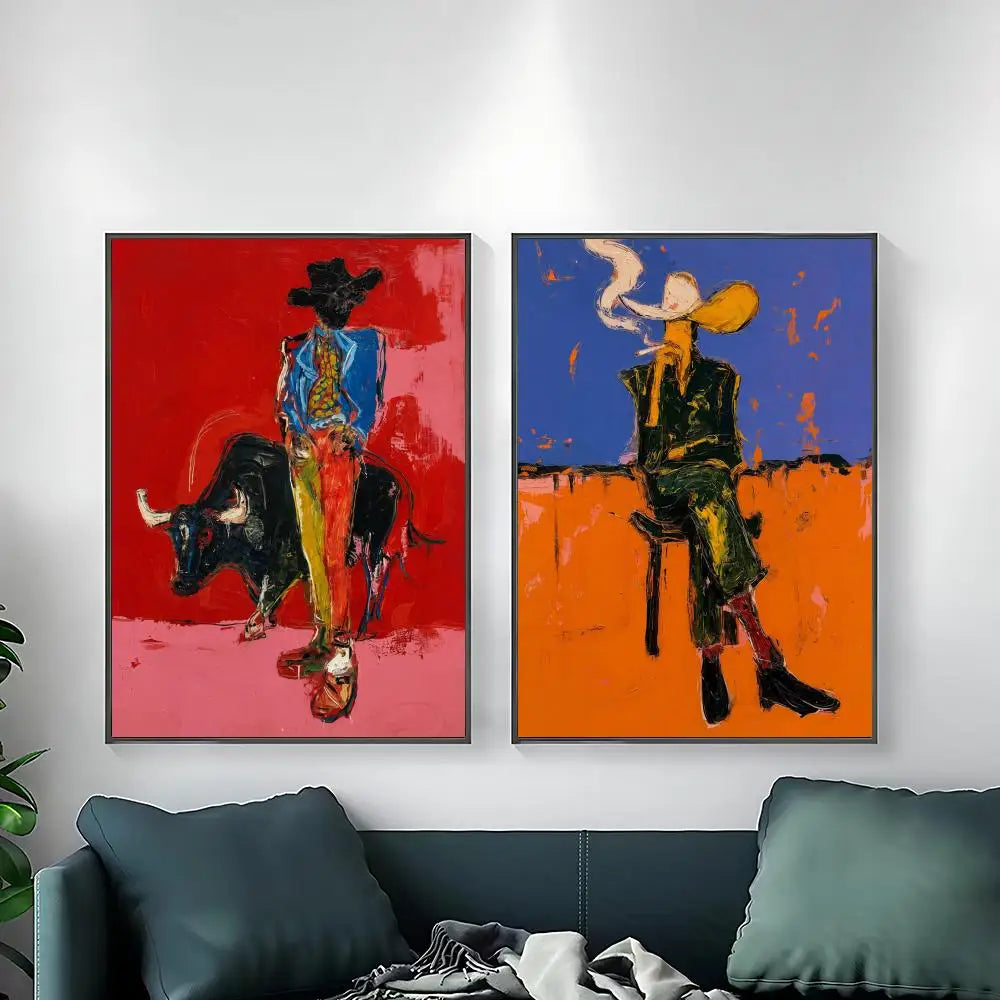 Two framed abstract art prints depicting stylized bullfighters hanging side-by-side on a white wall above a dark teal sofa.