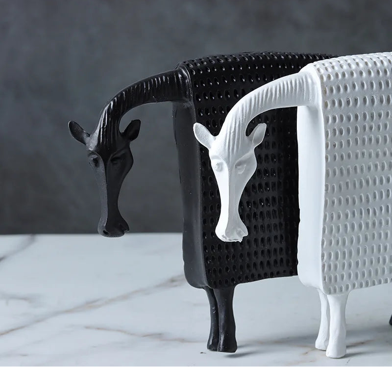 Two decorative horse figurines, one black and one white, on a marble surface with a dark background.