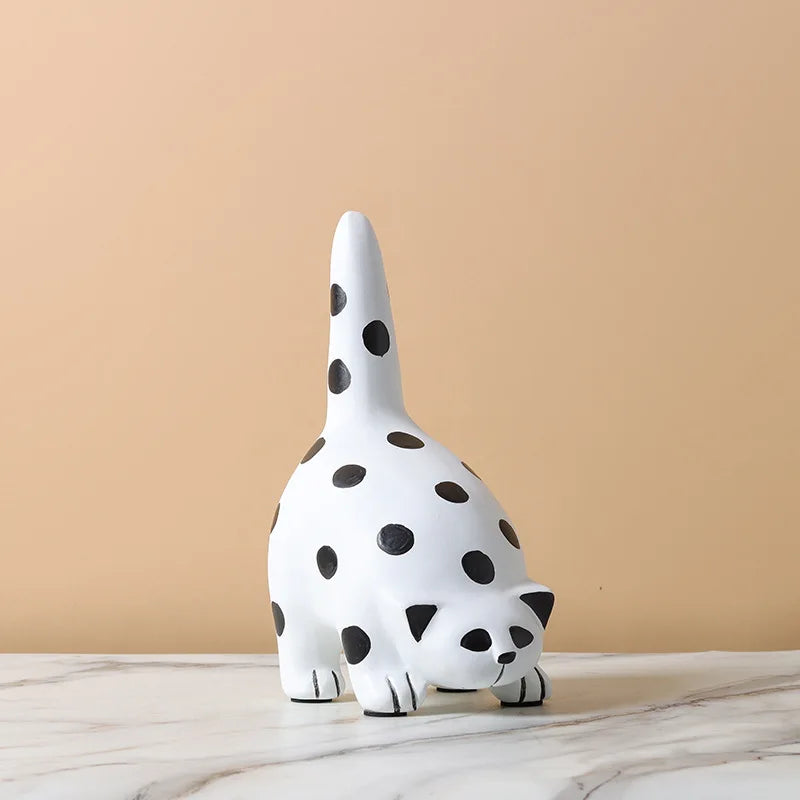 Whitecat figurine with black spots on a beige background