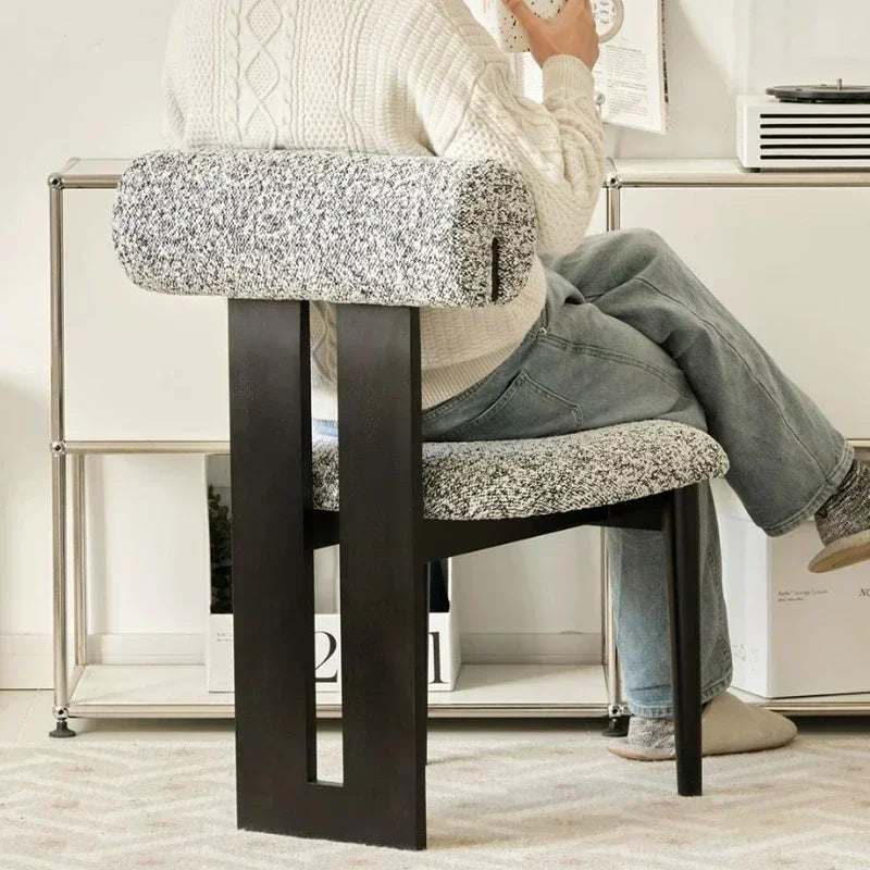 Person sitting on a chair with a textured cushion in a home setting