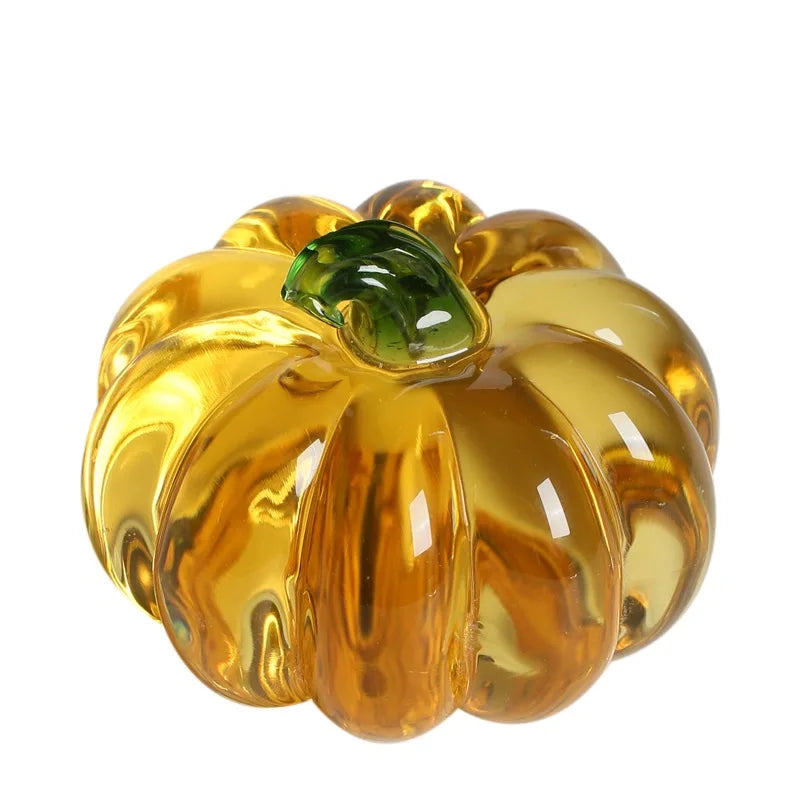 Glass pumpkin with a green leaf on a white background