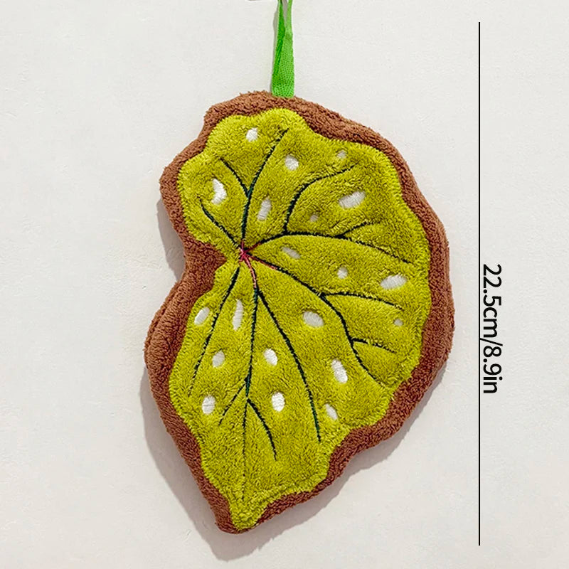 Leaf shaped hanging hand towel made from soft coral fleece fabric displayed beside a bathroom sink