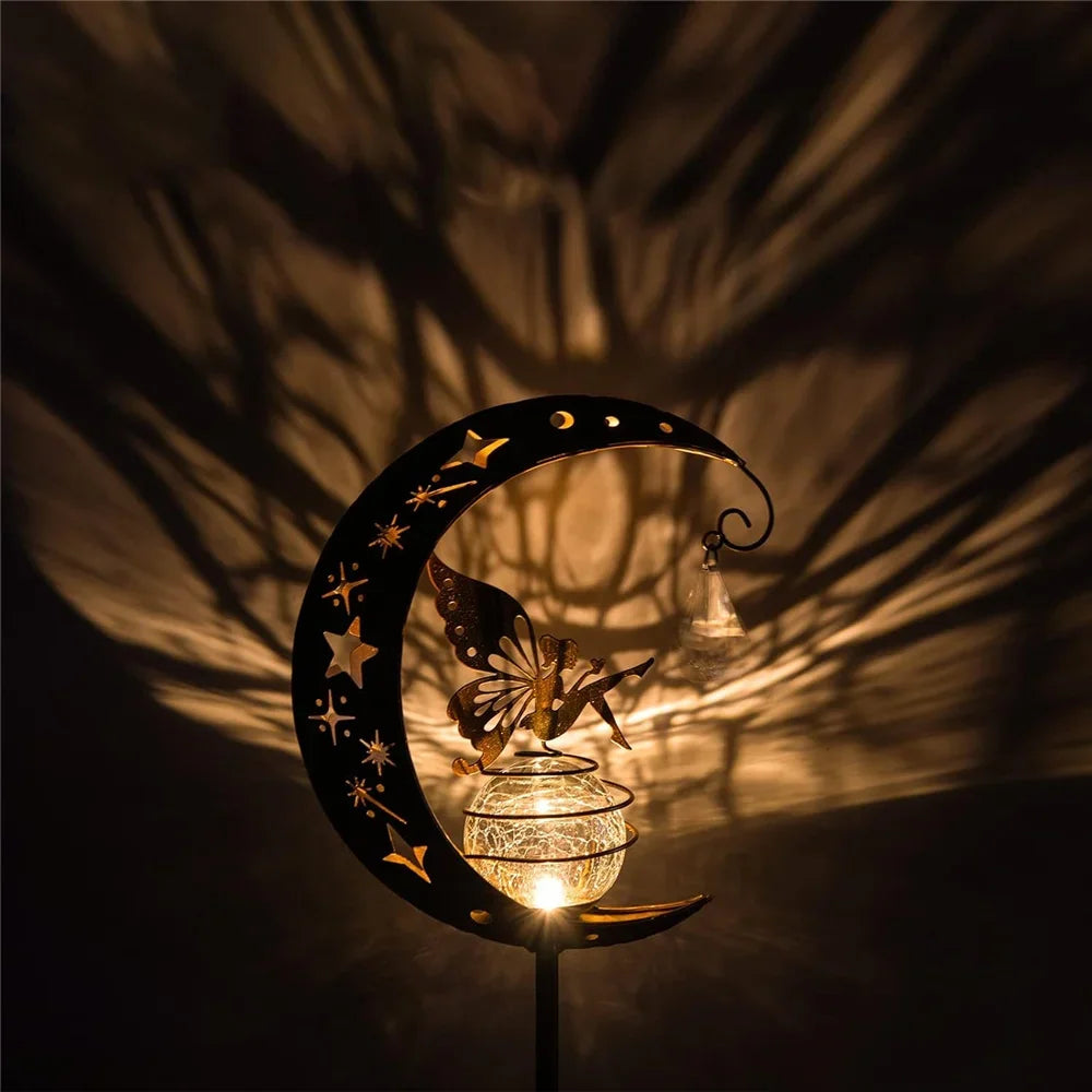 Decorative lamp shaped like a crescent moon with a fairy with a warm glow on a dark background