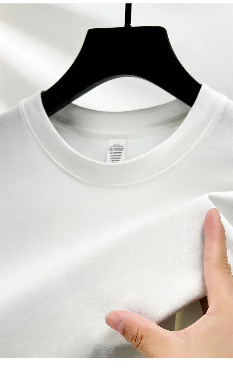 White t-shirt on a hanger with a hand touching the fabric