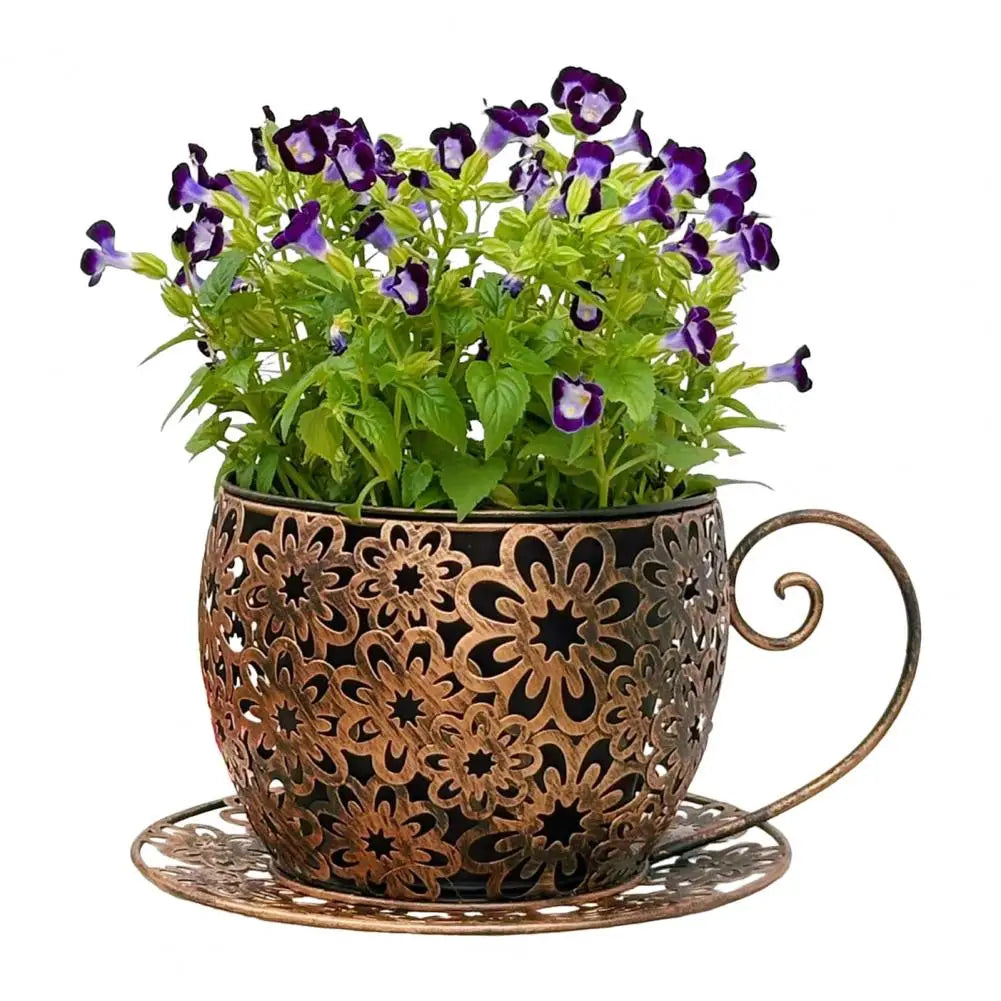 Decorative metal planter shaped like a teacup with purple flowers on a white background