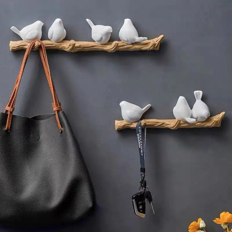 Decorative wall hooks with bird designs on a dark gray background