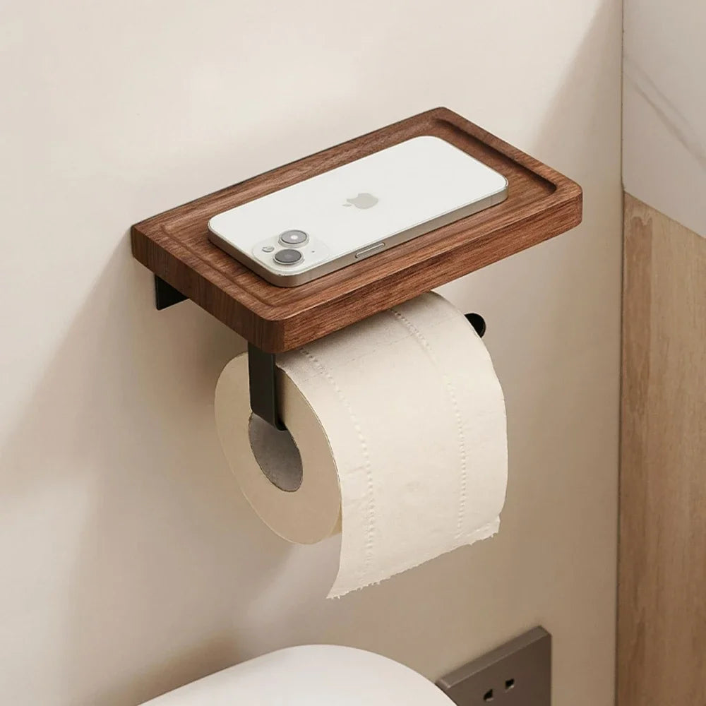 Wooden shelf mounted on a wall with a smartphone and toilet paper roll.