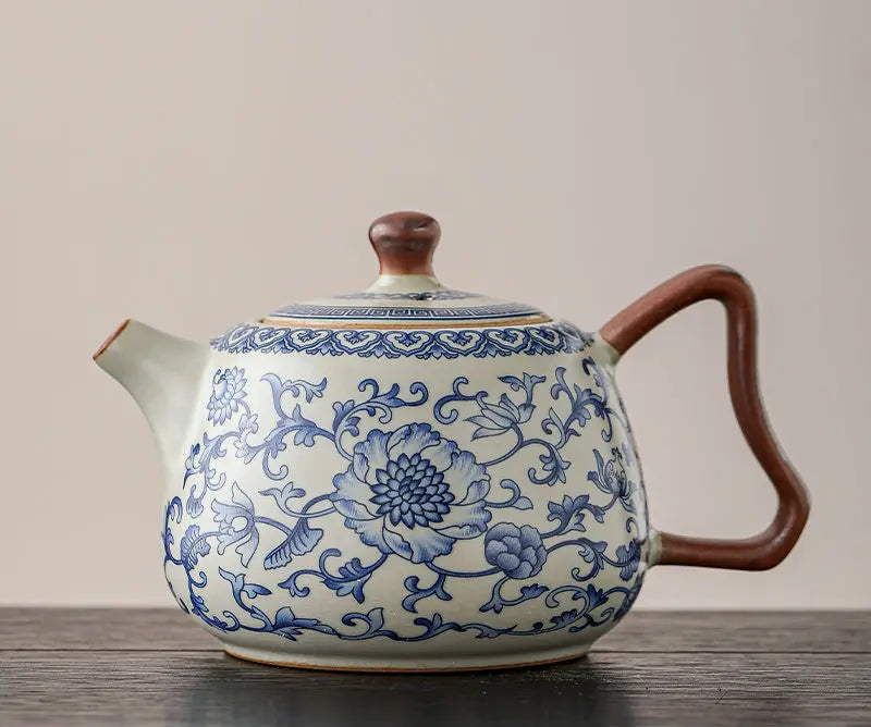 Ceramic teapot with blue floral patterns on a wooden surface