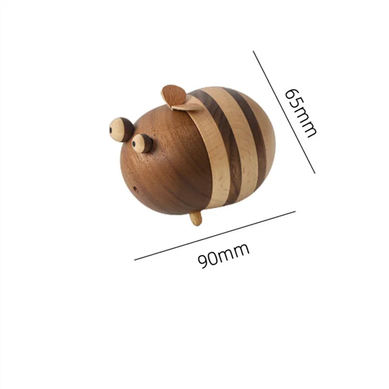 Two handcrafted wooden bee toothpick holders with striped natural wood finish displayed on a wooden tabletop as decorative kitchen accessories.