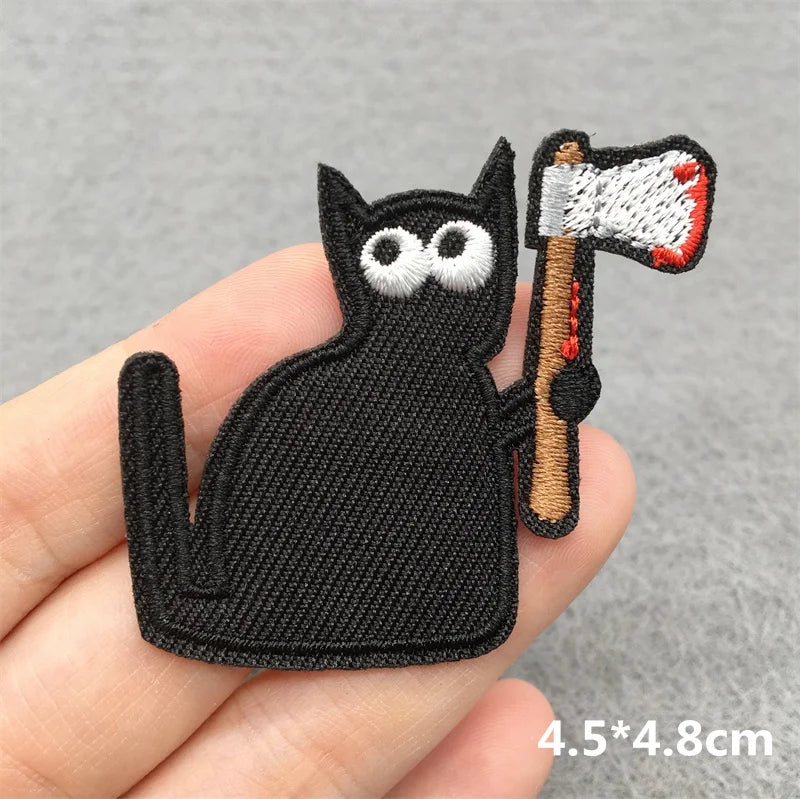 Black cat patch holding an axe on a gray background