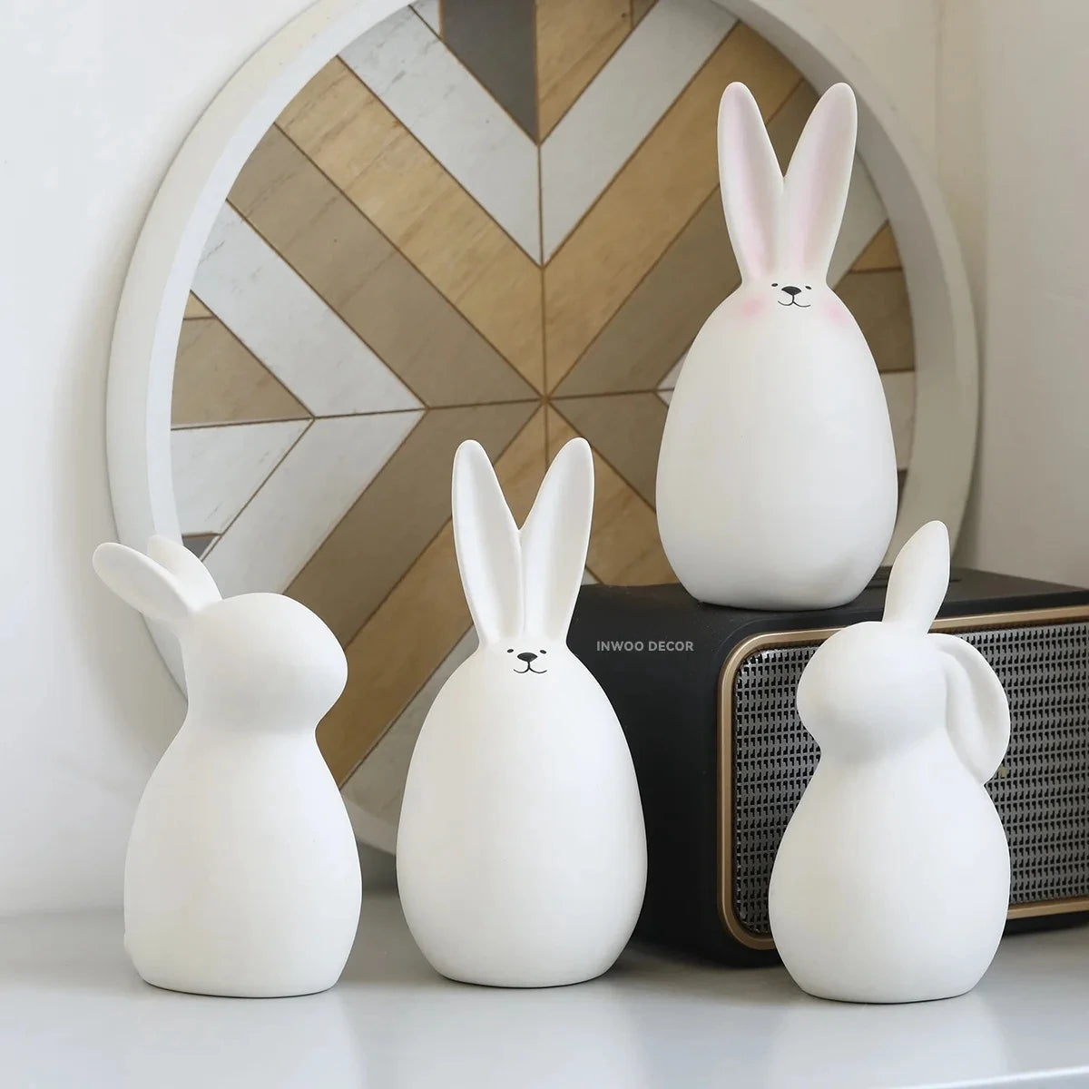 Three white rabbit-shaped lamps on a surface with a decorative mirror in the background.