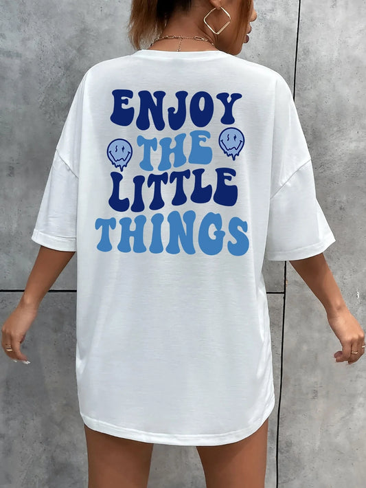 White t-shirt with blue text 'ENJOY THE LITTLE THINGS' on a gray background