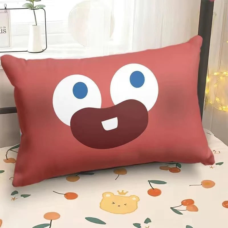 Red pillow with a cartoon face on a bed with a floral pattern