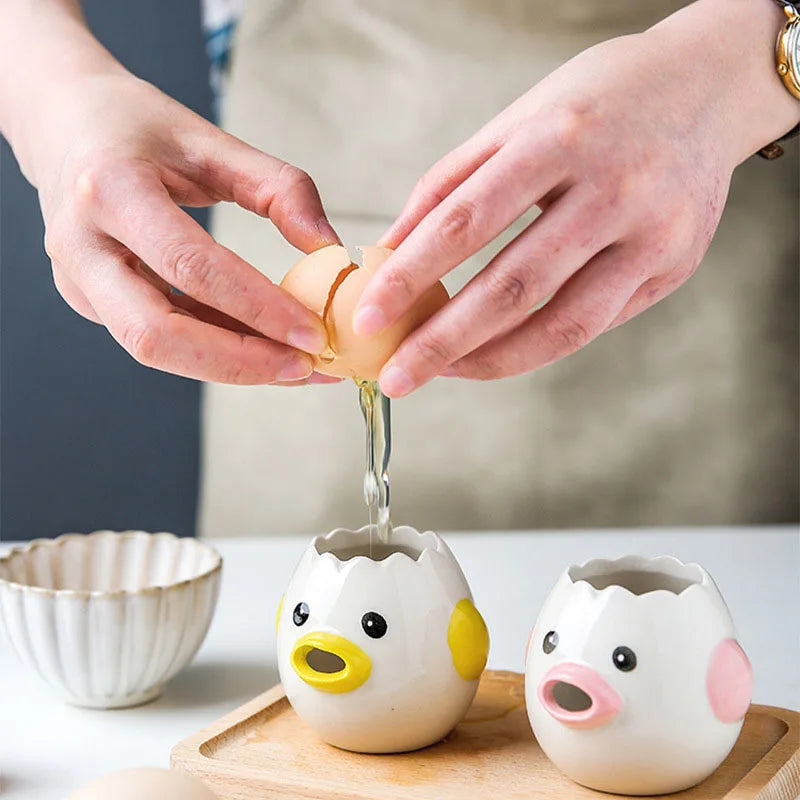 Person cracking an egg into a ceramic duck-shaped container on a wooden board.