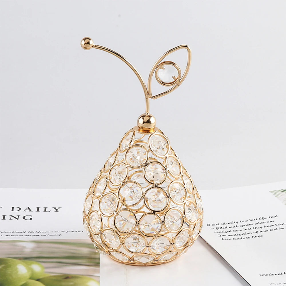 Decorative pear object with crystal details on a white surface