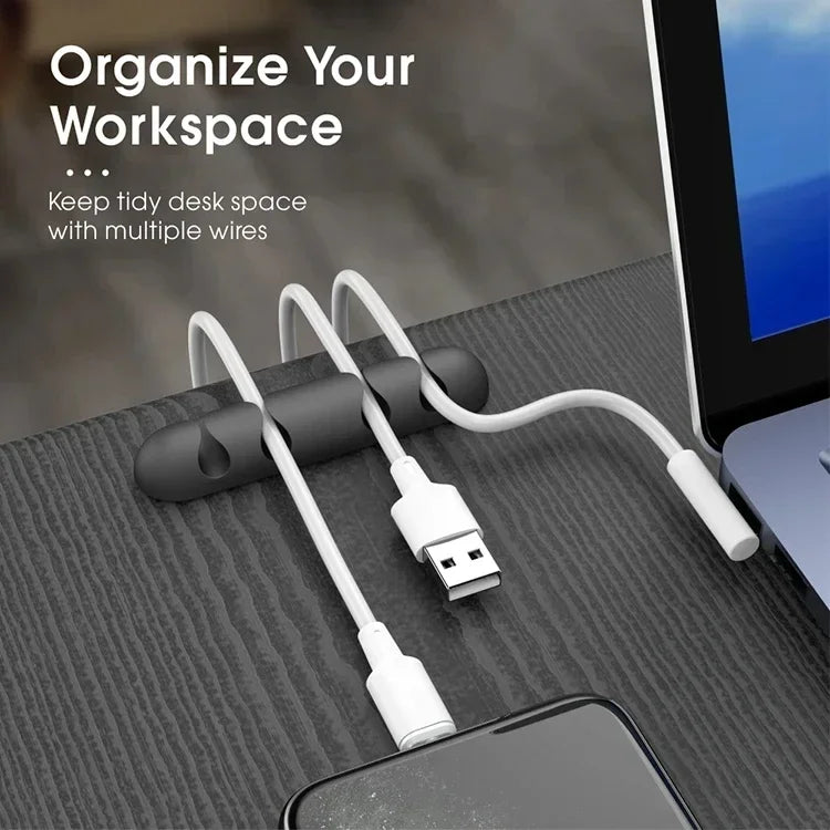 Desk organizer with multiple cables on a desk next to a computer screen.