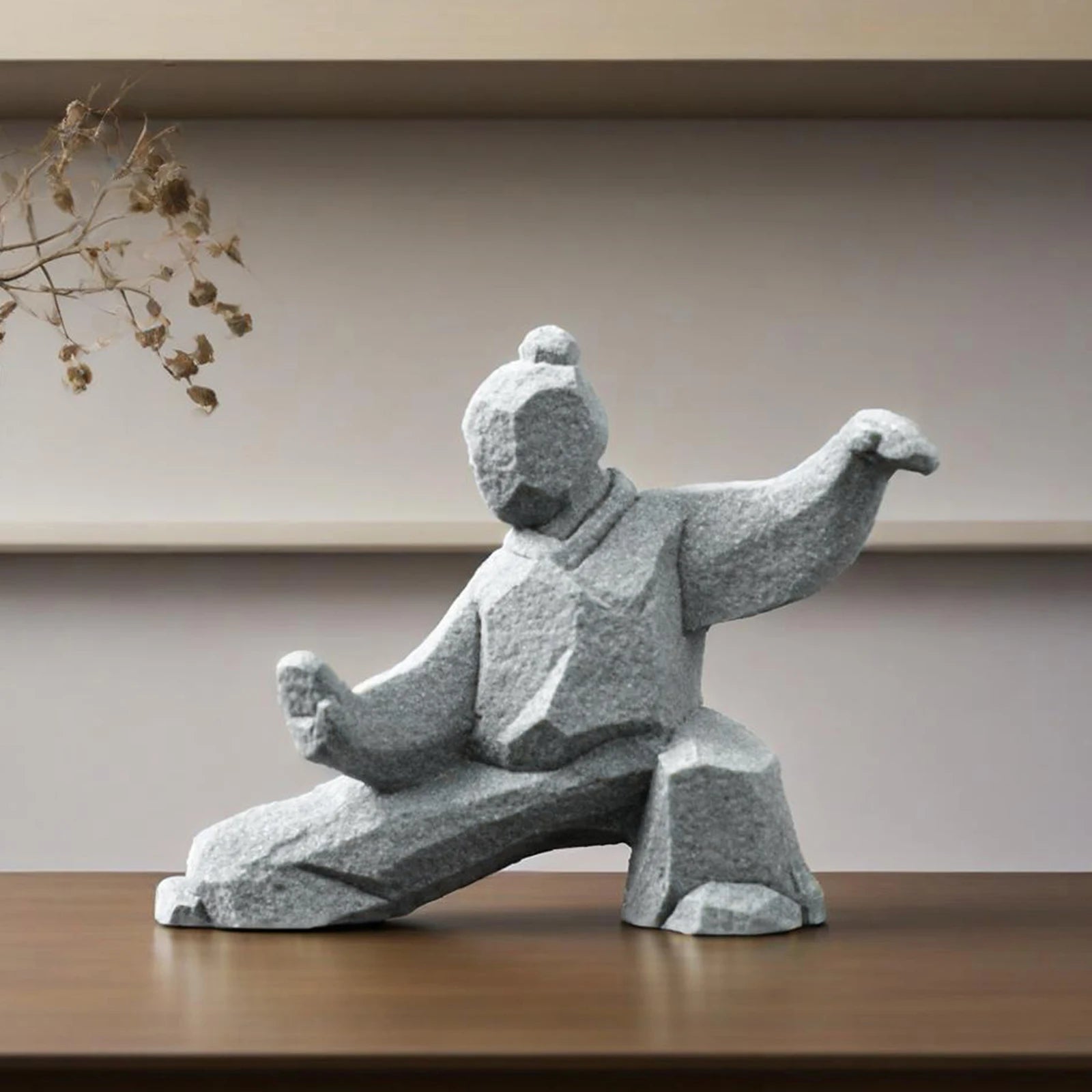 Stone sculpture of a martial artist in a dynamic pose on a wooden surface with a neutral background
