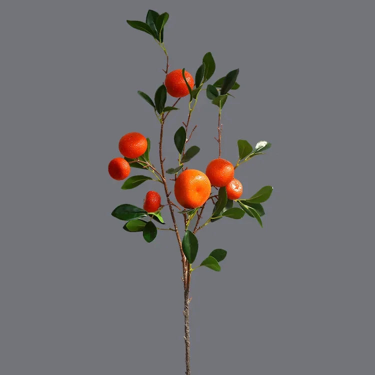 Artificial orange tree branch with oranges on a gray background