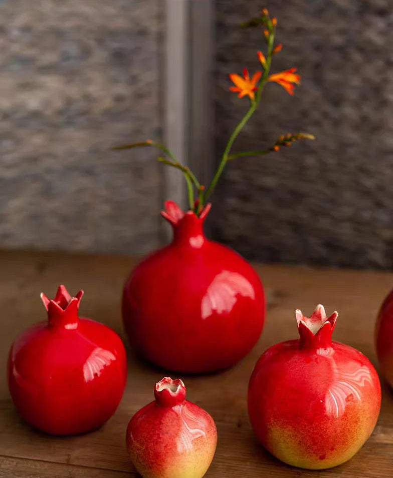 Red ceramic vases with floral decorations on a wooden surface
