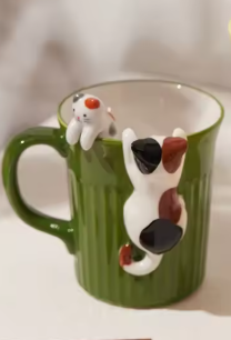 Green and yellow ceramic cat mugs with a 3D cat climbing over the rim.