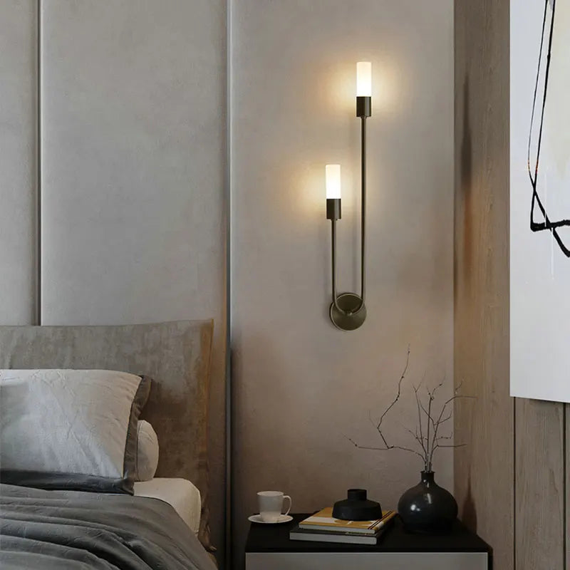 Modern wall sconces in a bedroom setting with a bed and nightstand.