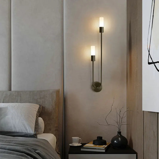 Modern wall sconces in a bedroom setting with a bed and nightstand.