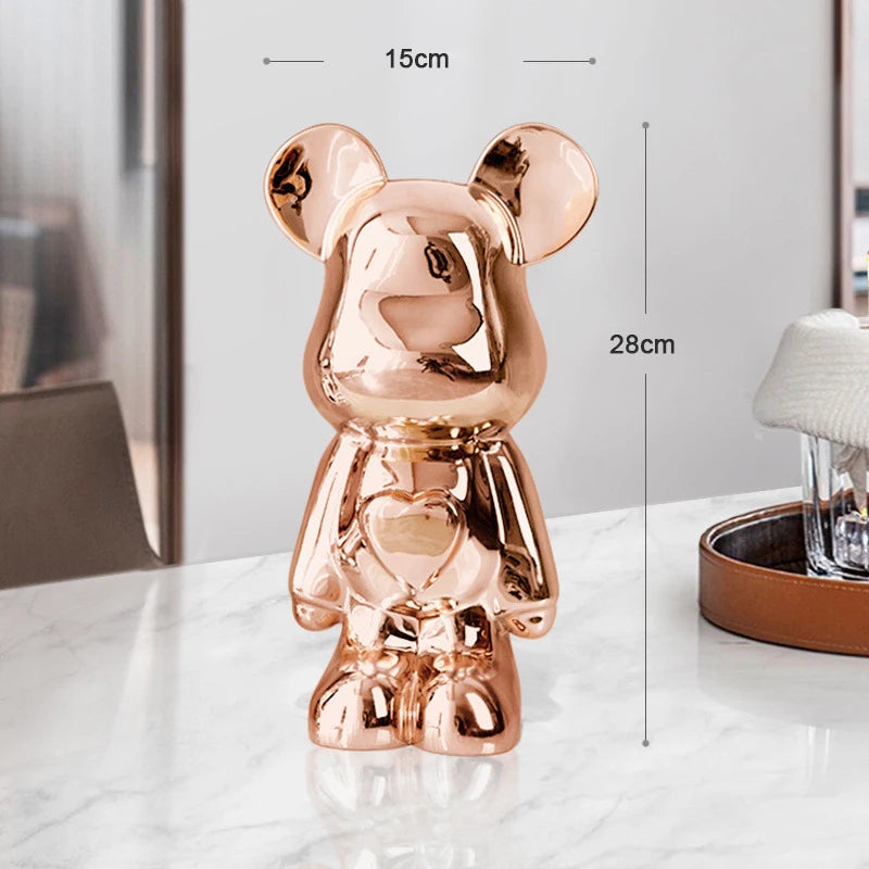 Rose gold teddy bear figurine with measurements on a white surface