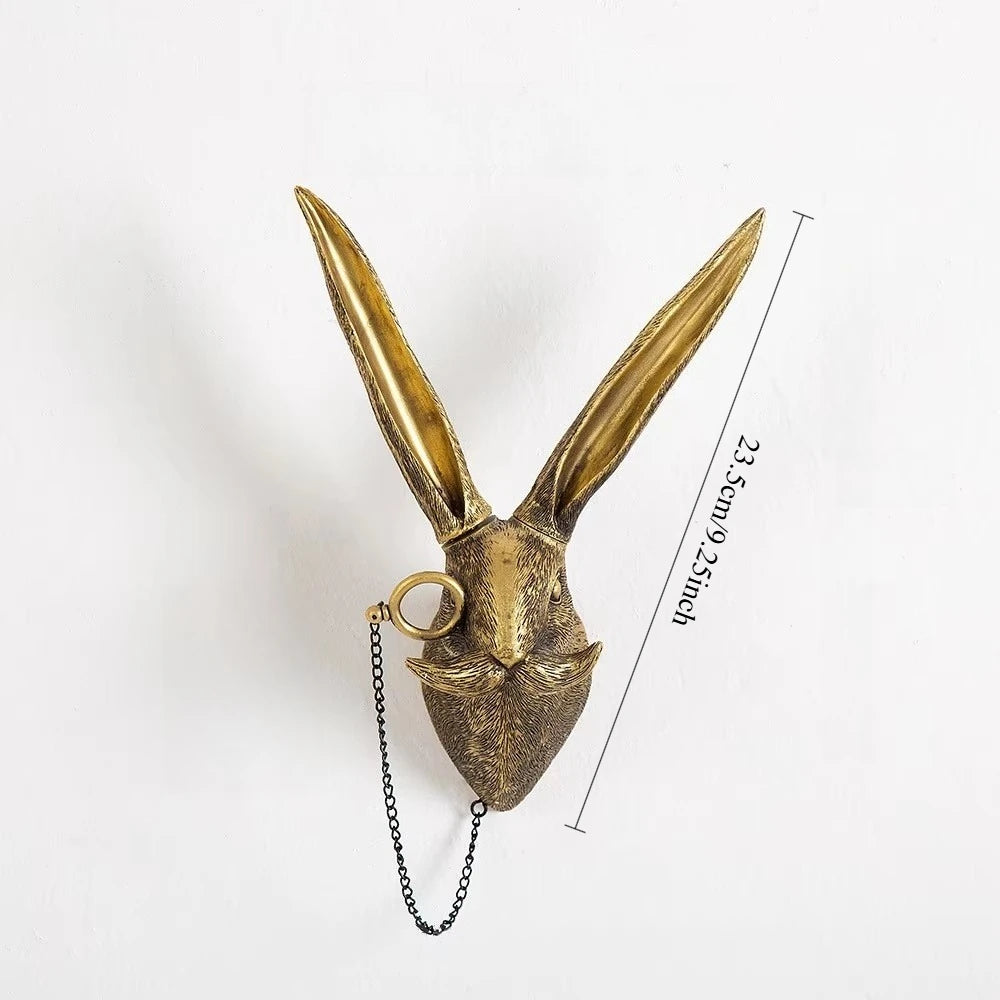 Gold rabbit head wall decoration with chain on a white background