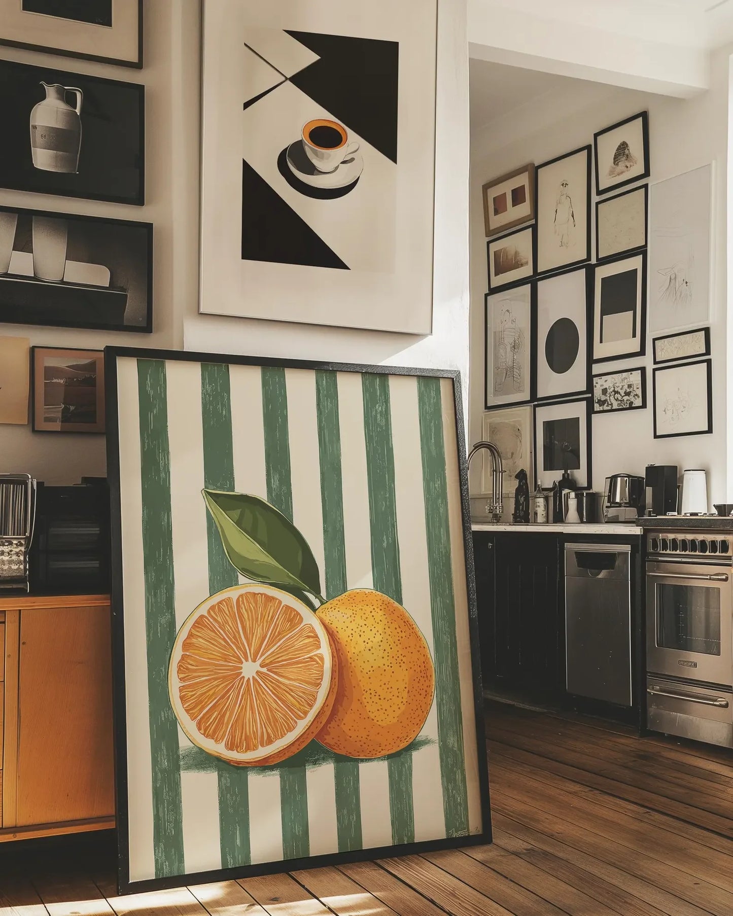 Framed artwork of oranges on a striped background in a kitchen setting