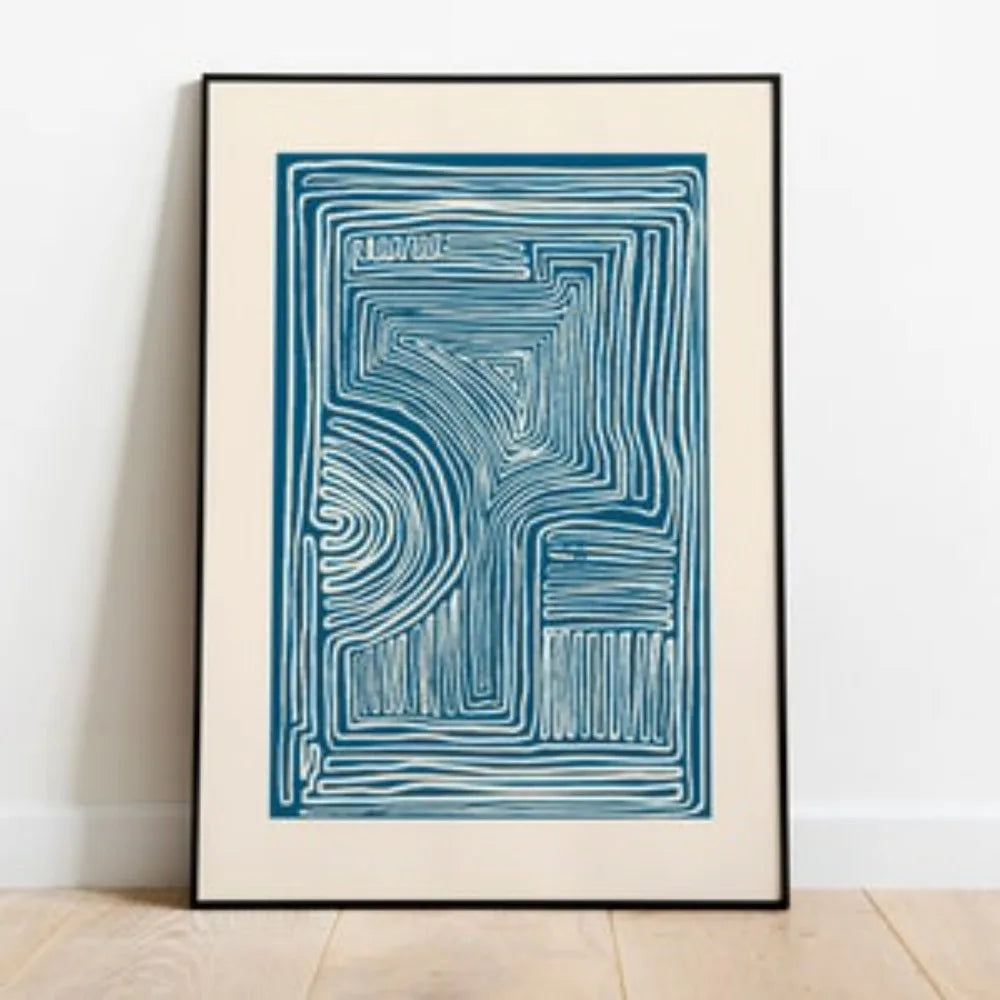 Framed abstract artwork with blue lines on a white wall
