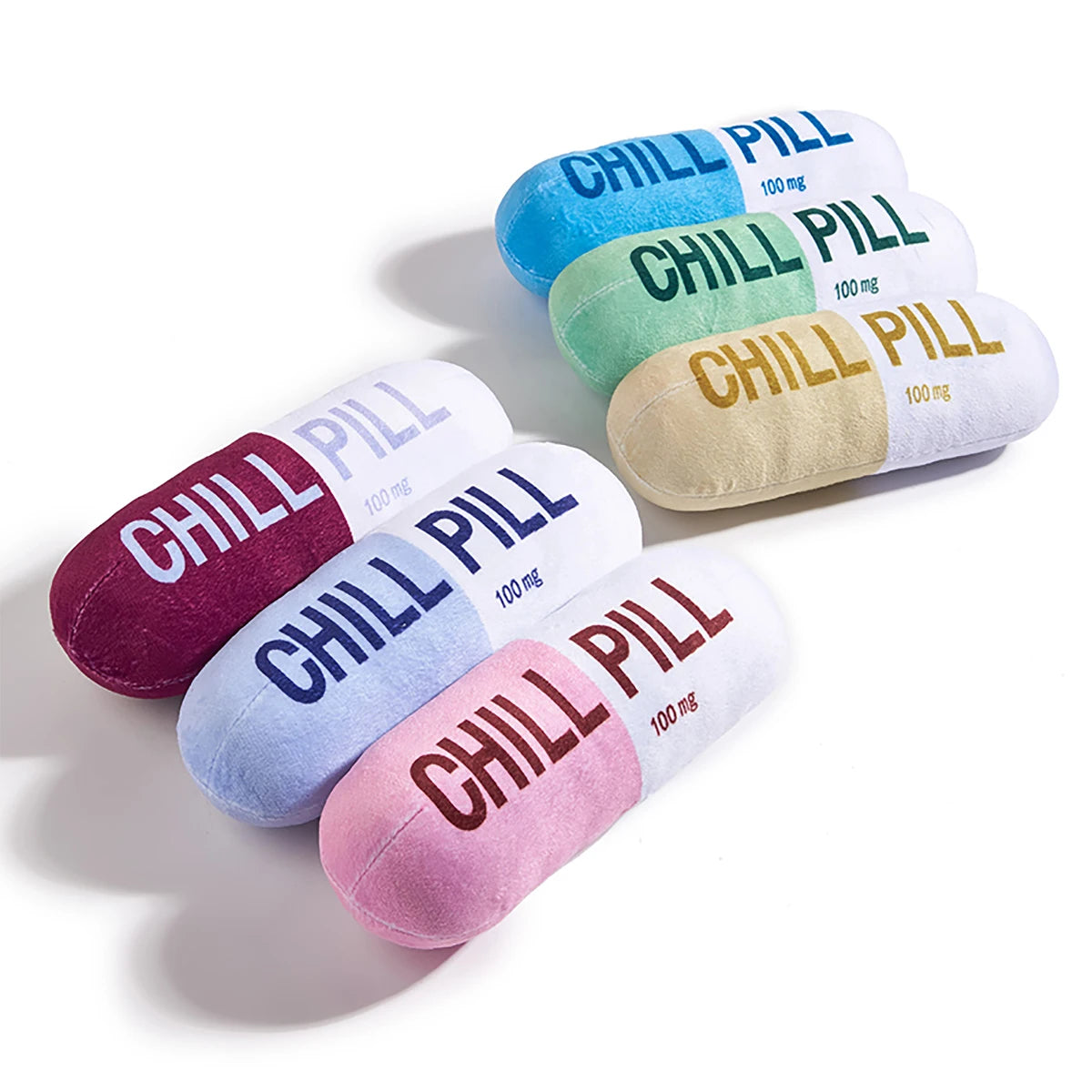 Colorful 'Chill Pill' plush toys on a white background