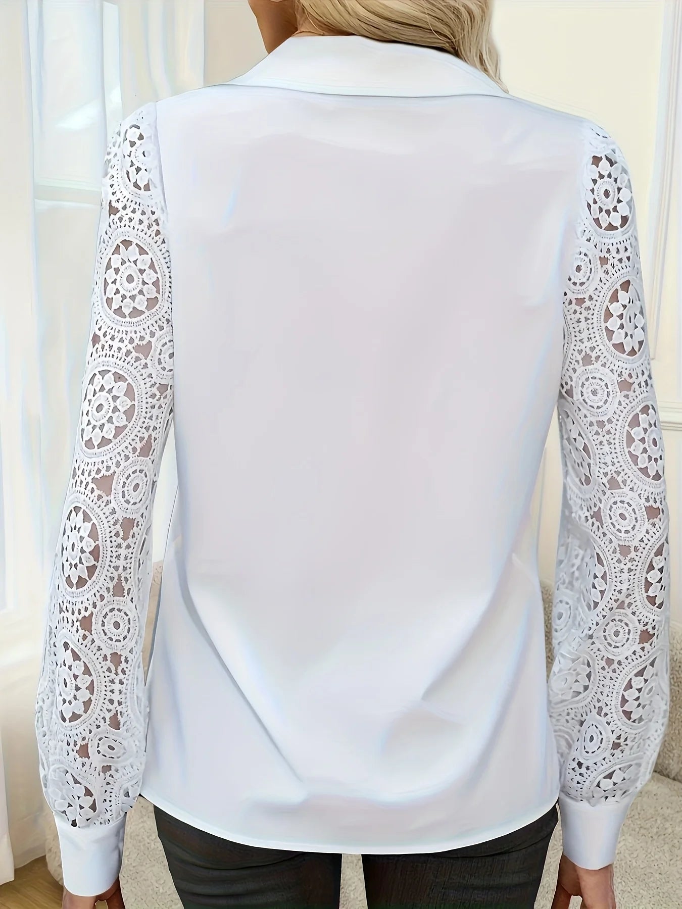 White blouse with lace sleeves on a neutral background
