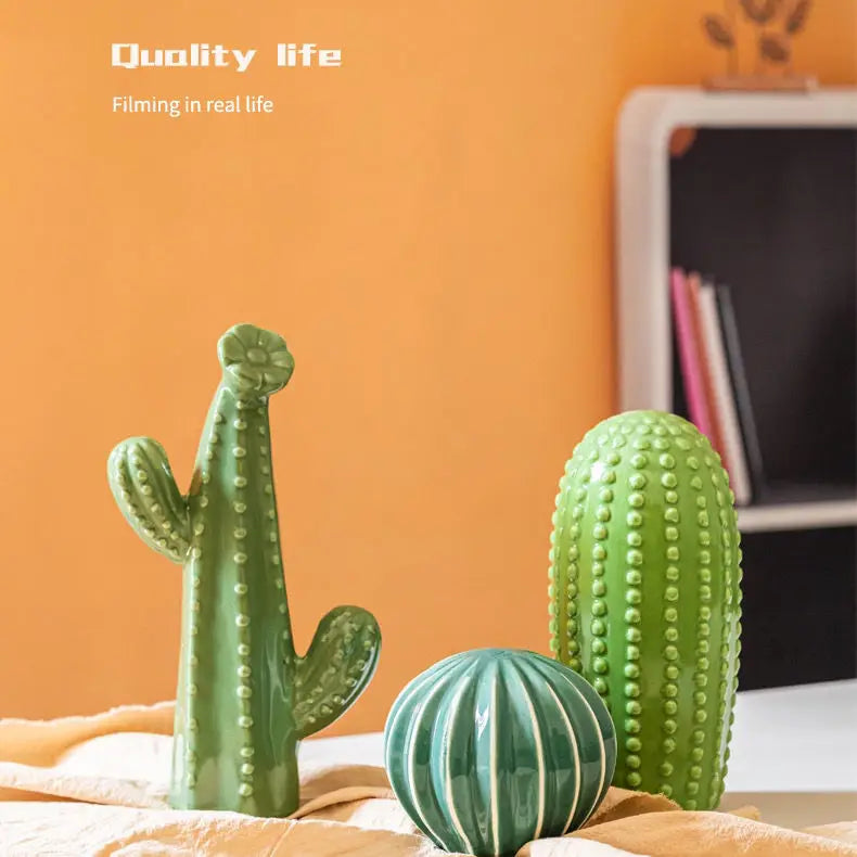 Decorative cacti on a surface with an orange wall in the background