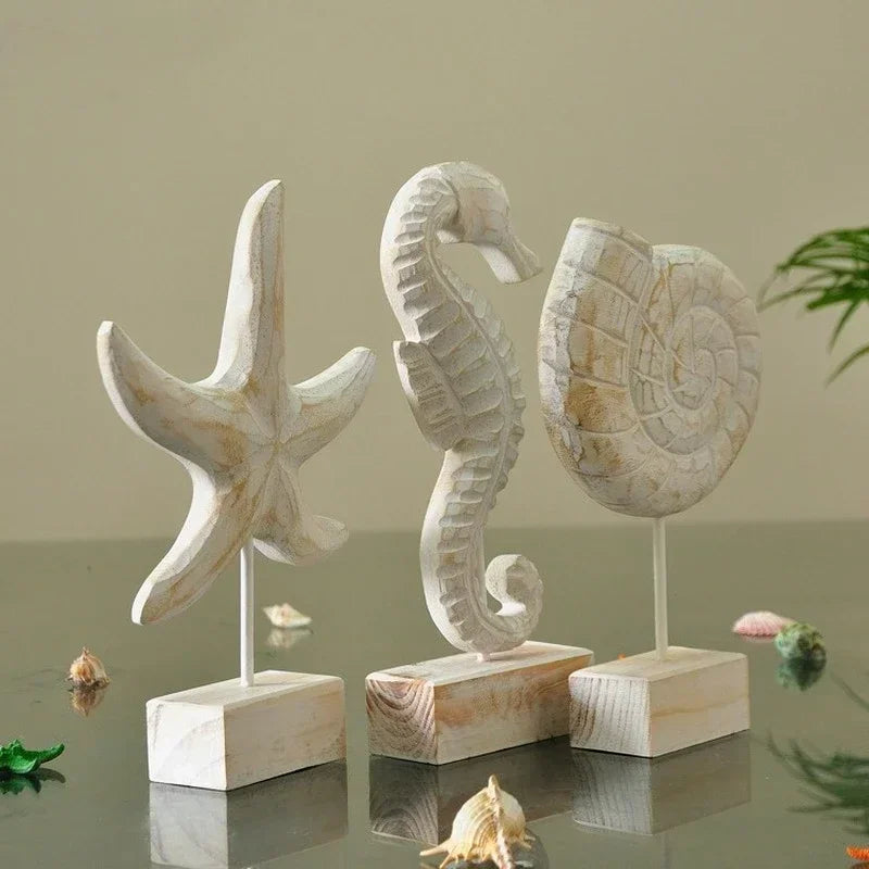 Mediterranean coastal wood sculptures featuring starfish, seahorse, and shell ornaments displayed on wooden stands in neutral interior styling
