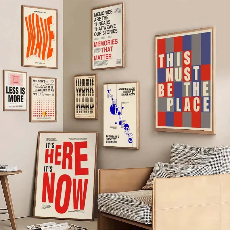 Wall with framed posters and a bed in the foreground