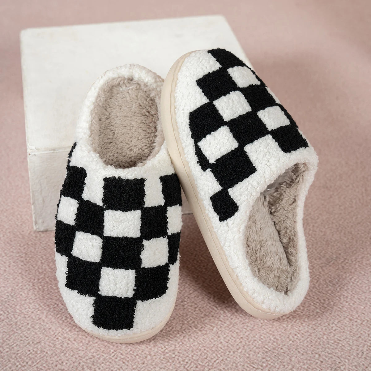Pair of checkered slippers on a pink background