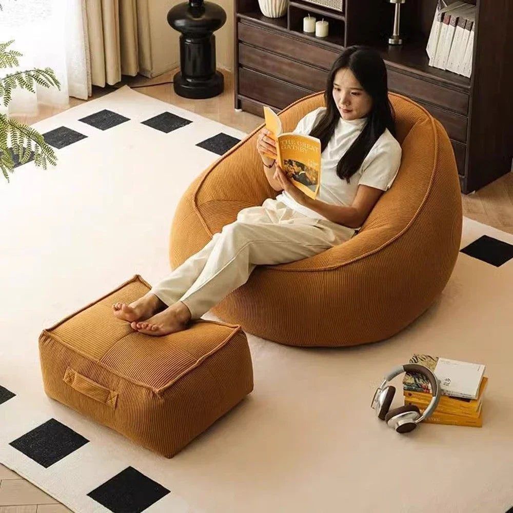 Woman reading a book on a brown bean bag chair in a cozy living room.