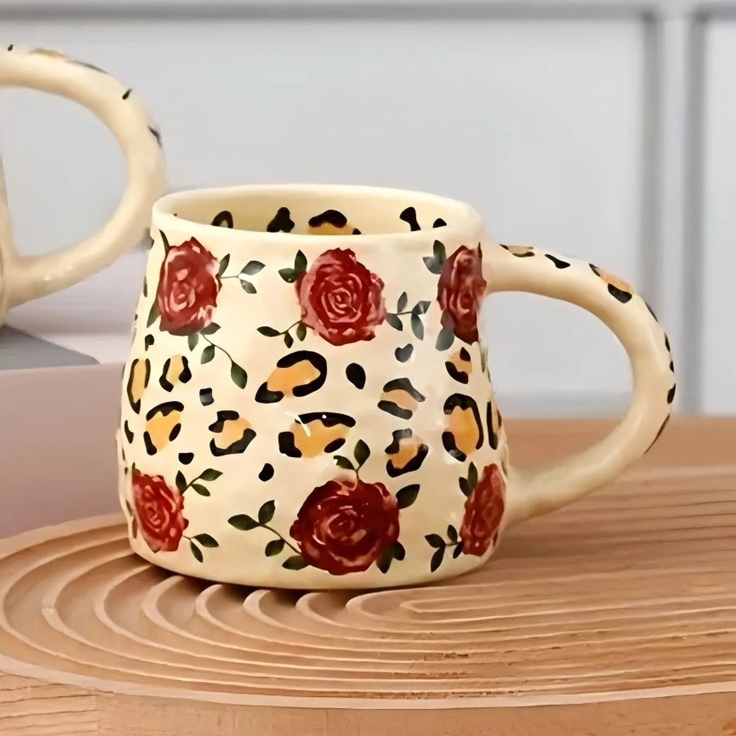 Mug with floral and leopard print design on a wooden surface