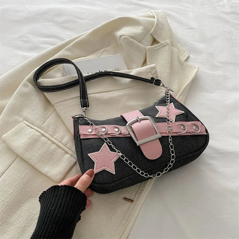Black handbag with pink star accents and a chain detail on a white surface.