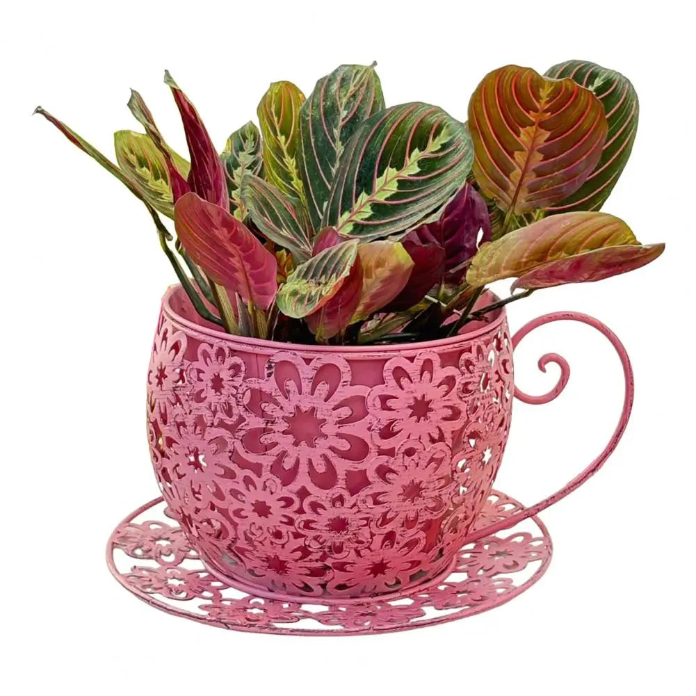 Pink decorative planter with intricate designs filled with colorful plants on a white background