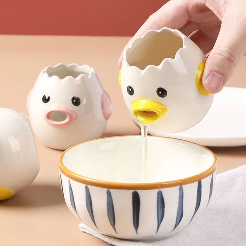 Cute ceramic chick-shaped egg white separator pouring egg white into a bowl while retaining the yolk for baking and cooking.