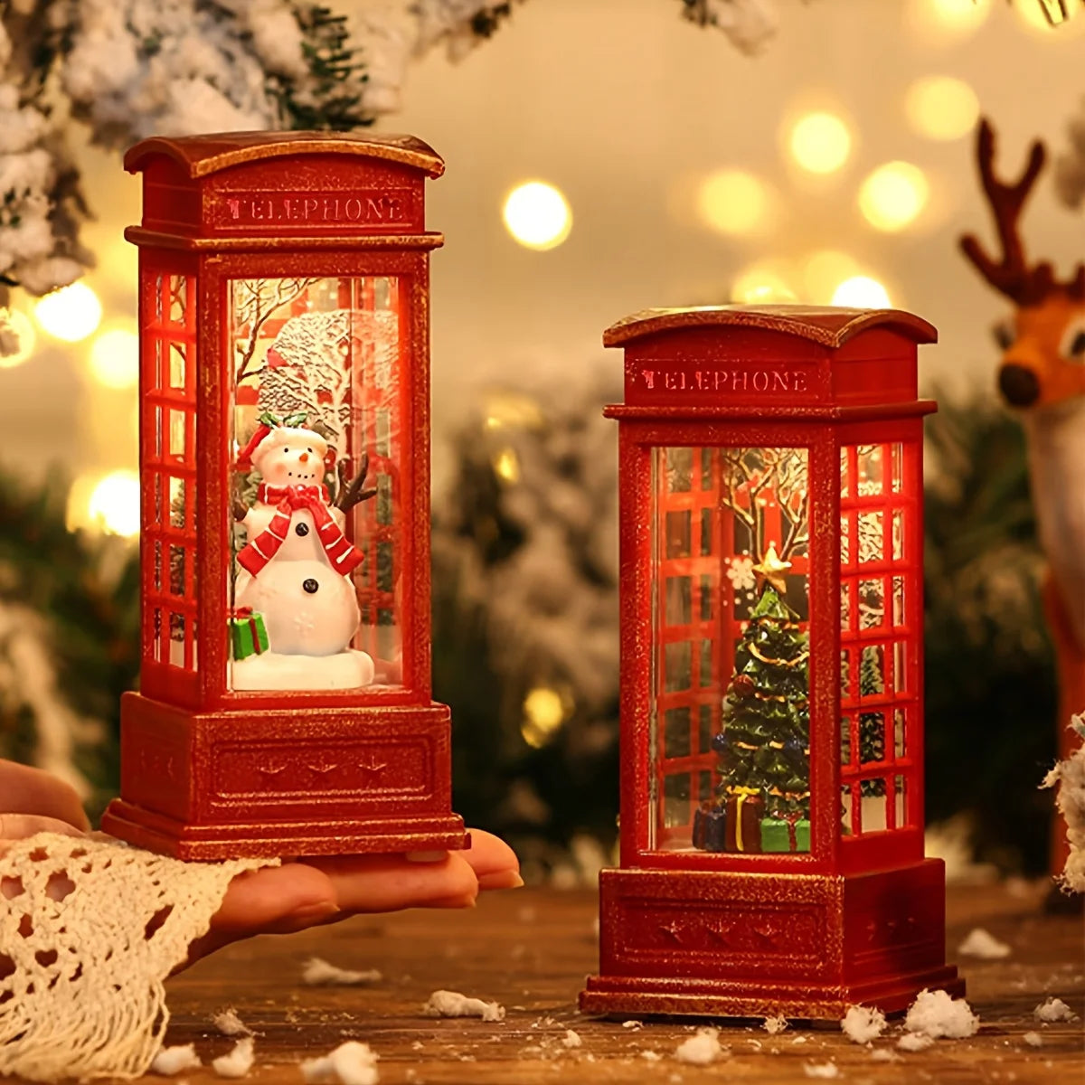 Red telephone booth snow globes with snowmen and Christmas trees on a festive background.